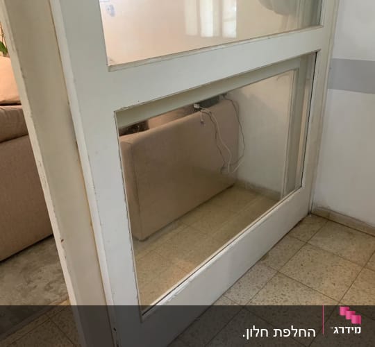 דלת זכוכית עם מסגרת לבנה בחדר פנימי